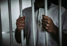 Cuba’s Easter Pardon: 2,010 Freed, Political Prisoners Ignored Person holding jail cell bars tightly.