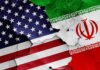 Cracked American and Iranian flags painted on a wall.