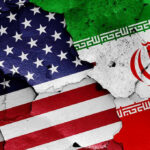 Cracked American and Iranian flags painted on a wall.
