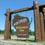 Wisconsin welcome sign with industry, agriculture, and recreation.