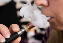 Close-up of a person vaping, exhaling smoke clouds