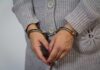 A person wearing handcuffs with their hands clasped together