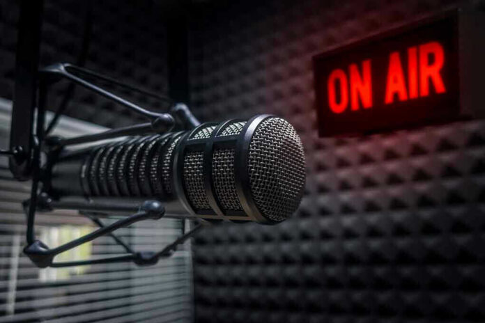 Microphone in soundproof studio with On Air sign.