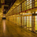 Prison Guard’s Murder Conviction Shocks Nation Empty hallway between rows of prison cells.