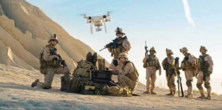 Soldiers operating a drone in a desert environment.
