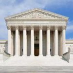 Trump Faces $83M Verdict Showdown Front view of the Supreme Court building with large columns and steps under a blue sky