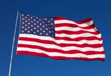 Waving American flag against a clear blue sky