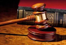 Judge’s Stunner: Internet Cheers For Killer A wooden gavel resting on a polished surface with a law book in the background