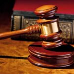Court Clerk Scandal Topples Murdaugh Verdict! A wooden gavel resting on a polished surface with a law book in the background