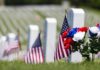 American flags and flowers placed at graves in a cemetery