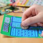 Lottery Miracle: $586K Win Follows Good Deed A person scratching off a bingo lottery ticket with a coin