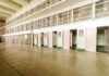 SHOCKING Suicides Surge in ICE Detention Interior view of a prison cell block with empty cells and security bars