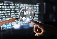 Poll Shocker: Media Rhetoric or Shooter to Blame? A hand pointing at the words 'FAKE NEWS' magnified by a glass