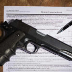 Gun and pen on firearm transaction form.