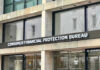 Bank Crackdown Targeting Illegals Consumer Financial Protection Bureau building entrance sign.
