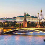 Ukraine Torches Moscow’s Fuel Lifeline Illuminated bridge and Kremlin complex across river at twilight.