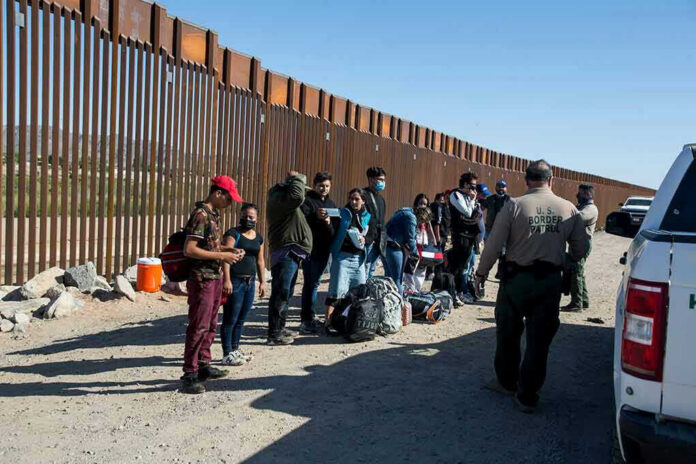 1973414822 Border patrol agents interact with a group of people.