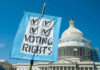 Sign reading Voting Rights in front of Capitol building.