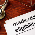 Rigged Medicaid Mega-Deal Exposed Stethoscope pen document about Medicaid eligibility on table