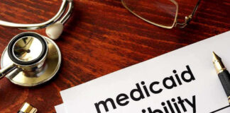 Stethoscope pen document about Medicaid eligibility on table