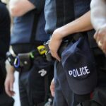 Group of police officers in uniform standing together with a police cap visible