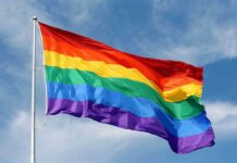 Shocking Arrest Torpedoes Pride Festival A rainbow flag waving against a blue sky