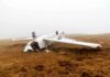 Crashed airplane lying on its side in a foggy field