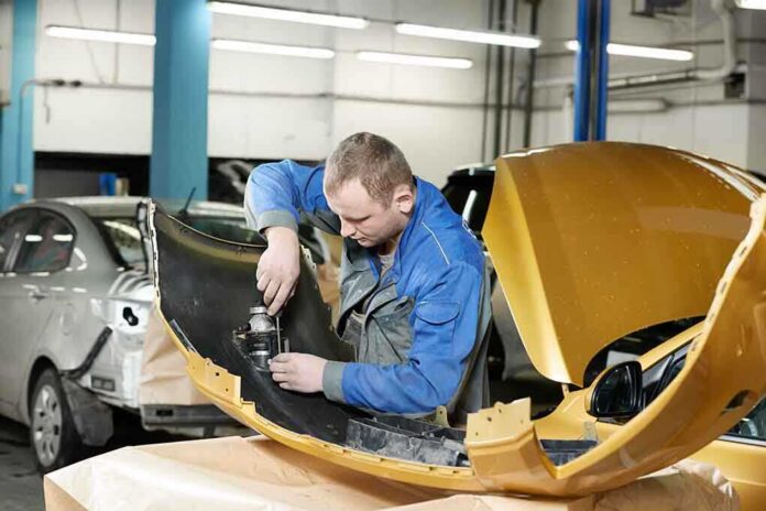 shutterstock_131353085 Mechanic working on a car part in a workshop