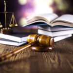 Judge Clears Mom In COVID ‘Baptism’ Death A gavel, legal books, and scales of justice on a wooden table