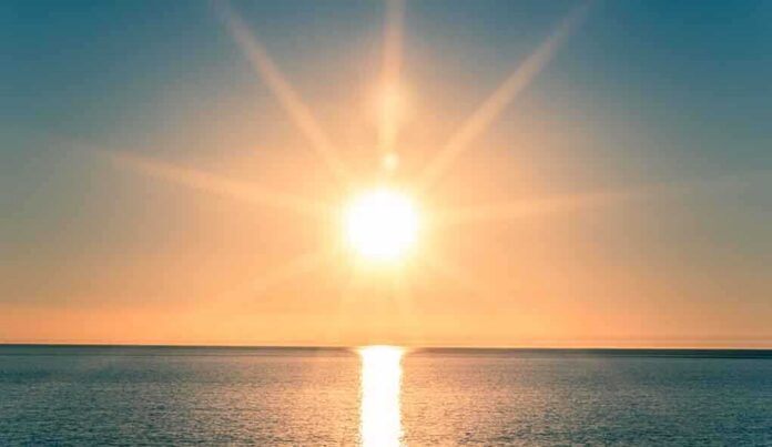 A serene sunrise over a calm ocean with vibrant colors in the sky