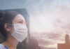 Air Turns Hazardous In Toronto Person wearing a mask in a cityscape background.