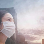 Air Turns Hazardous In Toronto Person wearing a mask in a cityscape background.
