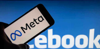 Meta on phone screen, Facebook in background.