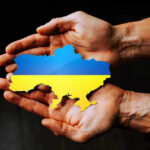 Zelenskyy’s Shock Purge Begins Hands holding Ukraine map with flag design.