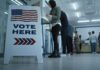 Patriotism Divide EXPLODES — Guess Who Plunged Sign reading Vote Here in a polling station.