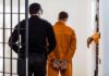 Prosecutors Blindsided — Child Killer Freed Prisoner in orange jumpsuit handcuffed and escorted by officer