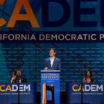 Democrats Borrow Trump—Blue MAGA? Speaker at podium during California Democratic Party event