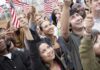 The World Cup is changing minds about America A diverse group of people joyfully waving American flags in celebration