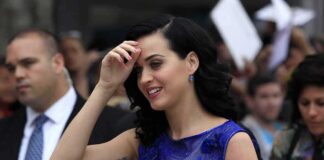 woman in a blue dress smiling at an outdoor event