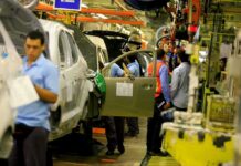 auto assembly line with workers installing car doors