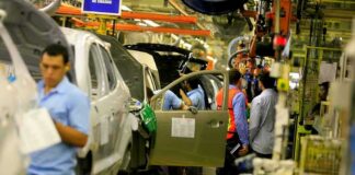 auto assembly line with workers installing car doors