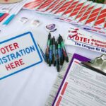 Homeless Exploited, Power Players Glide Voter registration table with forms, pens, and informational materials