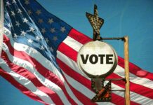 Trump Drops BOMBSHELL: China Voter Files A vintage Vote sign in front of an American flag