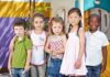 Locker Room Fight Explodes at YMCA Five children standing together in a playground setting, smiling at the camera