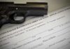 A handgun placed on top of a concealed carry license application form
