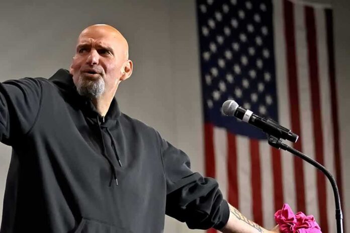 Bald man speaking at a microphone with a U.S. flag in the background