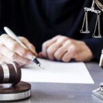 Biggest COVID Fraud? Still No Smoking Gun Judge writing at desk with gavel and Lady Justice statue