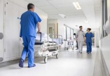 Hospital staff in scrubs walking in a bright corridor