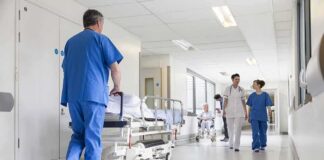 Hospital staff in scrubs walking in a bright corridor