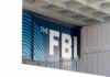 FBI sign on building facade behind metal fence